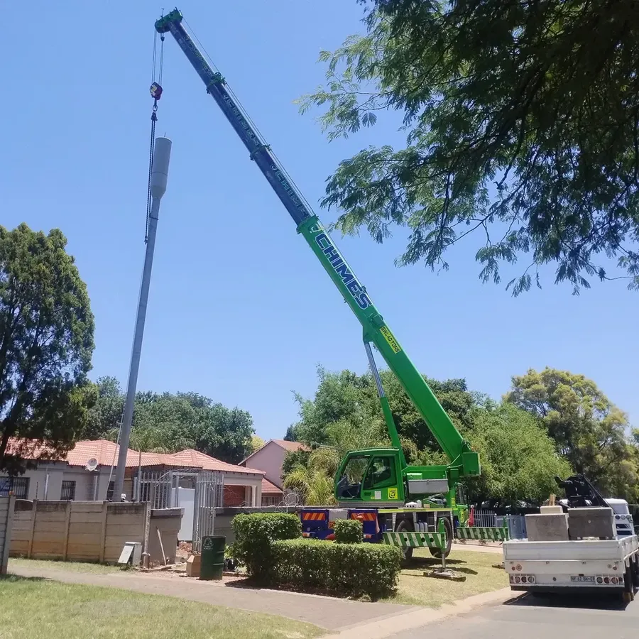 Crane lifting a telecoms pole into position
